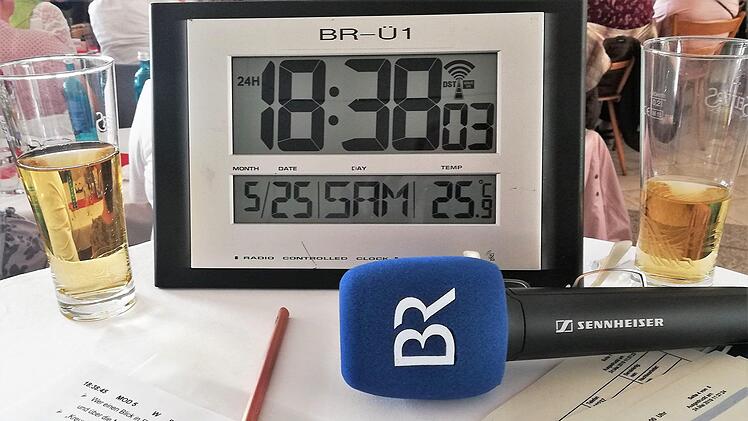 Die Uhr tickt: Der Arbeitstisch der beiden BR-Moderatoren Maria Bauer und Werner Aumüller während der Live-Sendung von "Musik & Xang" aus Bad Bocklet. Foto: Sigismund von Dobschütz