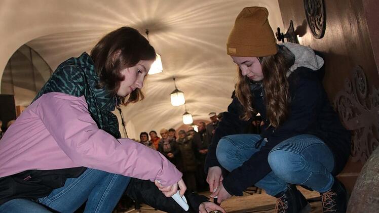 Schüler zündeten auf dem Weg zu den Gepäckstücken Kerzen an. Foto: Ralf Ruppert