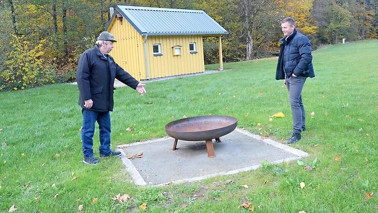 Mehrere solcher Feuerschalen hat Roland Ringlstetter (links) installiert und die Grillhütte im Hintergrund renoviert und neu eingerichtet. Für dieses außergewöhnliche ehrenamtliche Engagement gab es Anerkennung und Dank von Bürgermeister Stefan Heinlein .  Foto: K.- H. Hofmann