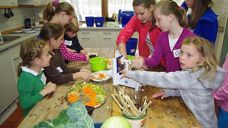Kim Werner und Lea Neubauer (stehend, von links) bereiteten mit den Kindern eine bunte Salatplatte zu. Foto: Heike Schülein