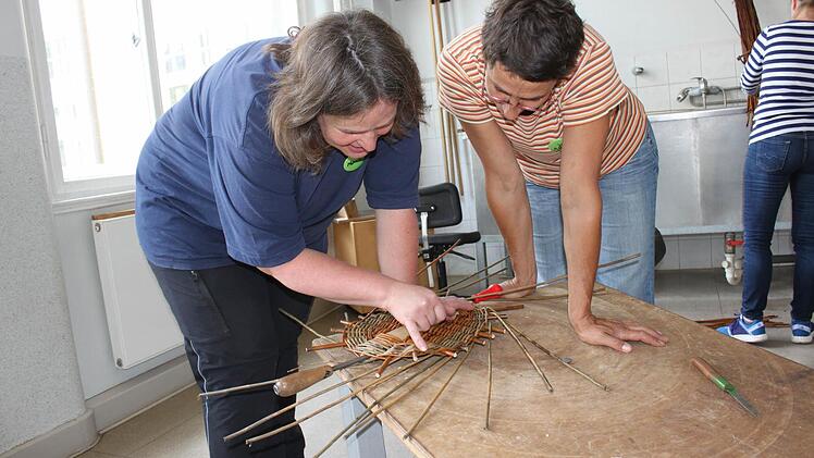 Monika Engelhardt (links) erklärt, worauf es beim Flechten des Bodens für einen ovalen Korb ankommt. Foto: Popp