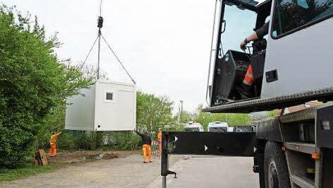 Ein Kran platziert einen der beiden Container. Foto: Arkadius Guzy