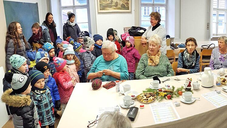 Überraschung für die Strick- und Häkeldamen im alten Rathaus von  Poppenlauer: Sie bekamen Besuch von Kindern der Kita Lauerland, die Weihnachtslieder sangen. Im Hintergrund in der Bildmitte Magdalena Dünisch,  die die Strick- und Häkeldamen zusammenhält. Dieter Britz
