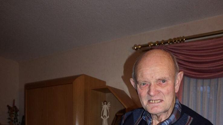 Hermann Ziegler mit einem Foto, das einen seiner Oldtimer-Traktoren zeigt. Marion Eckert