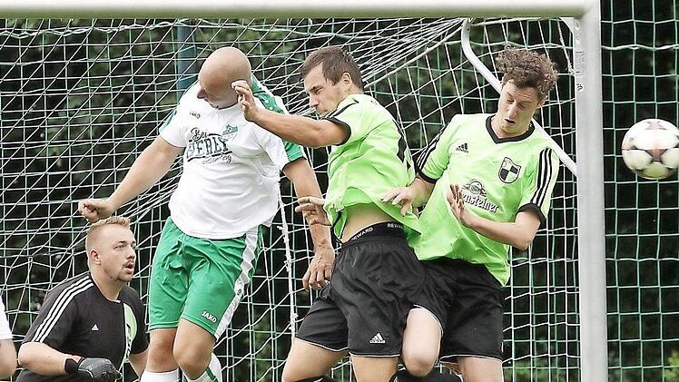 Daniel Hüttner (weißes Trikot) köpft den Ball aus dem Strafraum, die beiden Trunstadter Peter Zink und Julian Gann (r.) kommen nicht zum Abschluss. Der Bamberger Torwart Sebastian Kröner (l.) braucht nicht einzugreifen. Fotos: sportpress