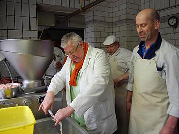 Metzgermeister Willy Sommer (rechts) schaut schmunzelnd zu, wie Gerald Heintze seine Idee von der Gurken-Bratwurst Wirklichkeit werden lässt. Foto: Oliver Schmidt