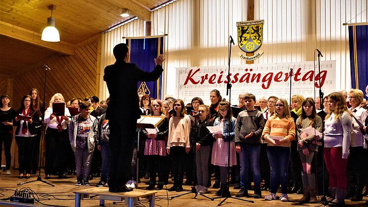 An die achtzig Sänger, darunter Schüler der Gottfried-Neukam-Mittelschule erfreuten unter der Leitung von Kreischorleiter Markus Häßler mit dem nachdenklich stimmenden Lied "Das Buch", in dem die mögliche Endzeitstimmung auf der Erde beschrieben wird. Gerd Fleischmann