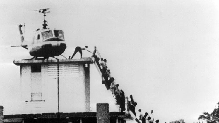 Menschen klettern 1975 zu einem der letzten Helikopter, der Saigon verlässt.