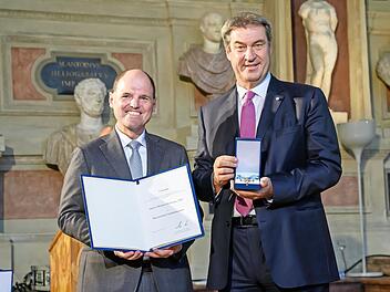 Ministerpräsident Markus Söder händigt Michael Hofmann den Verdienstorden aus.