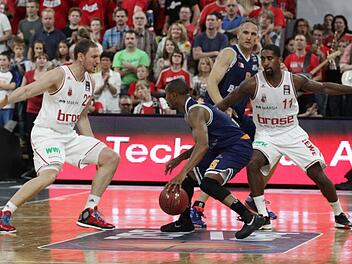 Mindaugas Katelynas (l.) und Brad Wanamaker (r.) verteidigen gegen den Bremerhavener Lorenzo Williams; im Hintergrund der Bamberger im Eisbären-Trikot, Sven Schultze. Foto: sportpress