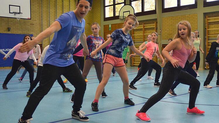 Profitänzer Krzysztof Malicki (links) zeigt den Schülern zu Beginn einfache Schrittkombinationen, die nach kurzer Einübungszeit auch schon gut klappen. Foto: Kathrin Kupka-Hahn