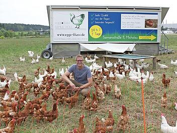 "Hahn im Korb" bei seinen Hühnern: Simon Holl wird von den Hennen gleich umringt, sobald er sich ins Freilaufgehege begibt. Die Tiere wissen, dass sie dann meist ein paar "Leckerli" extra bekommen. Foto: Popp