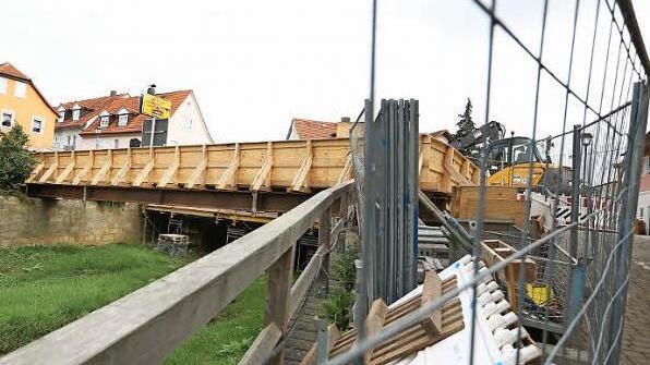 Fußgänger kommen auf dem hölzernen Provisorium über den Abgrund.