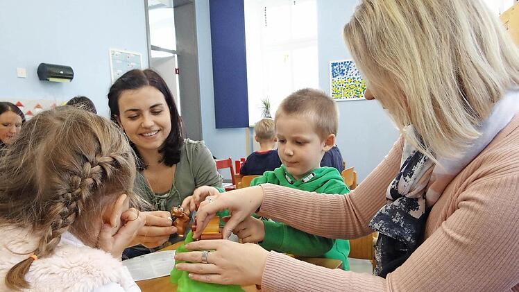Anna Gaspic (links) und Carmen Trinkerl (rechts) probieren gemeinsam mit ihren Kindern die neuen Spiele beim Eltern-Kind-Nachmittag im Kindergarten aus.