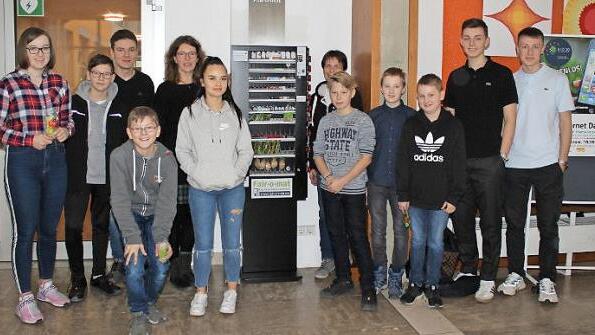 Die Sch&uuml;ler mit ihren Lehrerinnen Martina Wershofen (rechts am Automat) und Christiane Braun (links am Automat) sehen den Fair-o-mat als absoluten Gewinn f&uuml;r die Schule.
