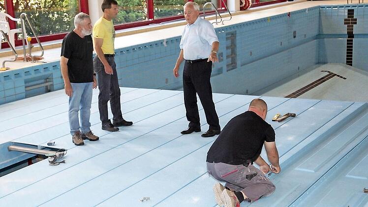 Bürgermeister Helmut Fischer, der Kämmerer Gerd Bergmann und Schwimmmeister Roland Mann überzeugten sich vom Fortschritt der Hubbodensanierung im Michelauer Bad. Insgesamt eine Woche werden die Arbeiten dauern.  Foto: Klaus Gagel