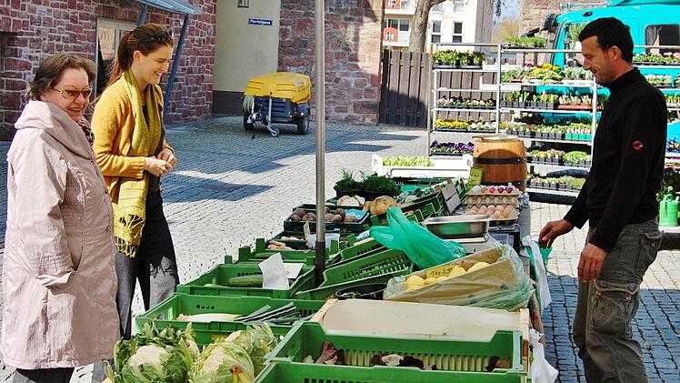 Juniorchef Alexander Wehner im Gespräch mit zwei Kundinnen am Grünen Markt.  Foto: Sigismund von Dobschütz