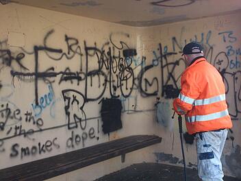 Mit dem Dampfstrahler rauen Mitarbeiter des Bauhofs die beschmierten Wände auf, um die Sprüche dann zu übermalen.  Foto: Andreas Dorsch
