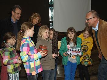 Thomas Henn (rechts) vom Ordinariat Würzburg schilderte den Grund- und Mittelschülern mit ihren Lehrkräften (im Bild: Rektorin Sonja Then und Konrektor Uli Müller) die Schulsituation in der Partnerdiözese Mbinga in Tansania. Von dort hatte er auch einige landestypische Dinge wie Ton-, Holz- und Stoffwaren mitgebracht.  Foto: Stefan Geiger