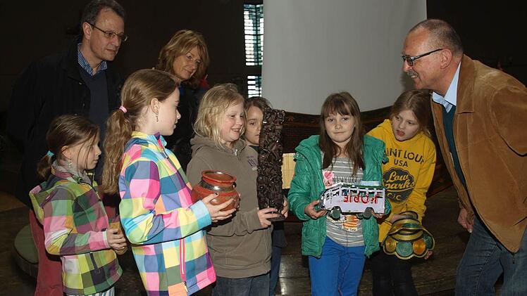 Thomas Henn (rechts) vom Ordinariat Würzburg schilderte den Grund- und Mittelschülern mit ihren Lehrkräften (im Bild: Rektorin Sonja Then und Konrektor Uli Müller) die Schulsituation in der Partnerdiözese Mbinga in Tansania. Von dort hatte er auch einige landestypische Dinge wie Ton-, Holz- und Stoffwaren mitgebracht.  Foto: Stefan Geiger
