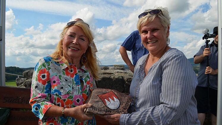 Ingrid Ott aus Rödental hat einen Stein mit dem fränkischen Rechen bemalt, den sie an Bürgermeisterin Uto Hopf übergibt. Foto: Gabi Bertram