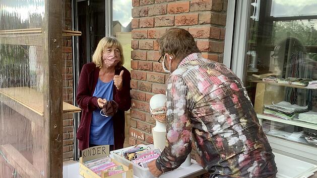 Gerlinde Ebert berät einen Kunden vor ihrem Nähzimmer in Westheim unter Einhaltung des Sicherheitsabstandes.  Foto: Bianca Volkert