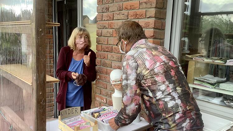 Gerlinde Ebert berät einen Kunden vor ihrem Nähzimmer in Westheim unter Einhaltung des Sicherheitsabstandes.  Foto: Bianca Volkert