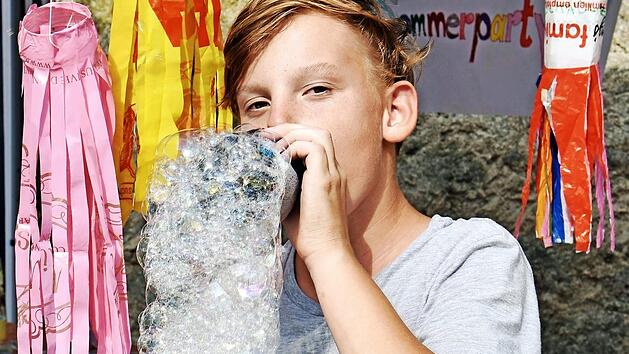 "Gartenzwerg" Maximilian Schonunger macht mit selbstgemachten Pusteflaschen Schaumschlangen.  Foto: Ulrike Langer