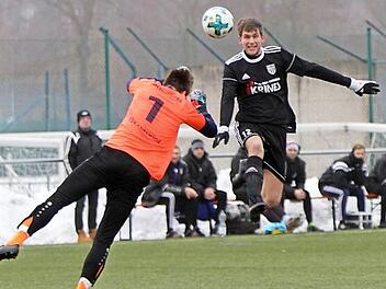 Aus dem Spiel des FC Sand gegen den TSV Abswind: G&auml;stetorwart Julian Schneider (links) kommt mit seiner Faustabwehr zu sp&auml;t, Christopher Gonnert k&ouml;pft zum 1:0 ein.  Foto: G&uuml;nther Geiling