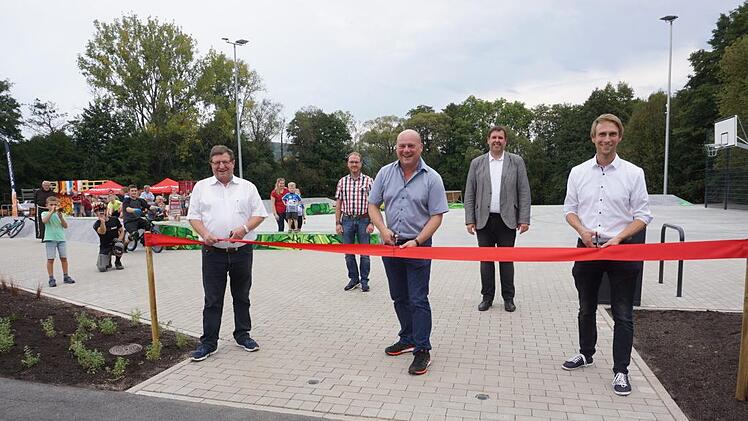 Eröffnung des "Funparks 4 Seasons": (vorne von links) stellvertretender Landrat Josef Demar, Bürgermeister Georg Seiffert und Alexander Zeller von der Regierung von Unterfranken beim Durchschneiden des roten Absperrbandes. Mit im Bild Pastoralreferent Stephan Tengler (2.v.l.) und der evangelische Pfarrer Oliver Englert (4.v.l.). Foto: Marion Eckert