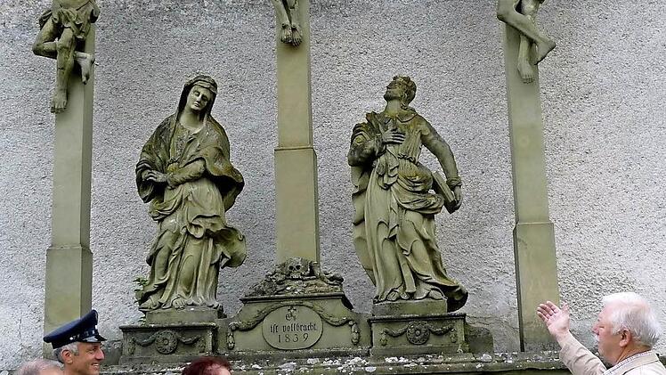 Karl Bauer sowie Michael, Monika und Fridolin Weigand stehen bei der Scheckübergabe vor der Kreuzigungsgruppe. Foto: Gaby Seifried