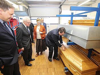 Das Sarglager im Bestatterzentrum besichtigten die Teilnehmer des Besprechungskreises Kirche und Handwerk. Christian Streidt, der Präsident des Bundesverbandes deutscher Bestatter, kontrolliert, ob ein italienischer Sarg vorschriftsmäßig verschraubt ist.Foto: Dieter Britz