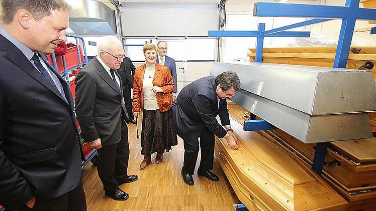 Das Sarglager im Bestatterzentrum besichtigten die Teilnehmer des Besprechungskreises Kirche und Handwerk. Christian Streidt, der Präsident des Bundesverbandes deutscher Bestatter, kontrolliert, ob ein italienischer Sarg vorschriftsmäßig verschraubt ist.Foto: Dieter Britz