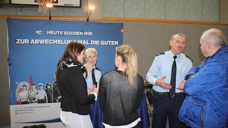 Bei der Bundespolizei sucht man Abiturienten, die später einmal mit Führungsqualitäten glänzen sollen. Die Bewerber sollten kommunikativ und teamfähig sein. Darauf legt Oberkommissar Jürgen Kauper (zweiter von rechts) im Gespräch mit Eltern und Schülern großen Wert. Auch Ausbildungsberaterin Stefanie Hempfling ist eine gefragte Ansprechpartnerin. Foto: Stephan Stöckel.