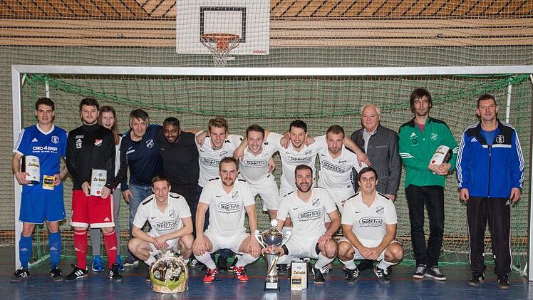 Bei den Herren ging der Wanderpokal endg&uuml;ltig in den Besitz der SpVgg Lettenreuth (wei&szlig;e Trikots) &uuml;ber. Sie stellte auch den Torsch&uuml;tzenk&ouml;nig. Mit im Bild auch der Schirmherr,  B&uuml;rgermeister Helmut Fischer (stehend, Dritter von rechts),  den Turnierleiter Gerd Bergmann und die Spielf&uuml;hrer der &uuml;brigen Teams.  Foto: Klaus Gagel