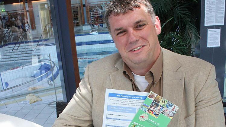 Werkleiter Hans-Josef Stich zeigt den Fragebogen der Therme und eine Broschüre zum Entdeckerpass. Foto: Tobias Kindermann
