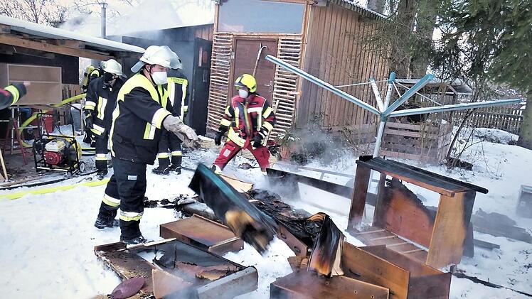 Feuerwehrleute brachten angesengte Möbelstücke ins Freie.