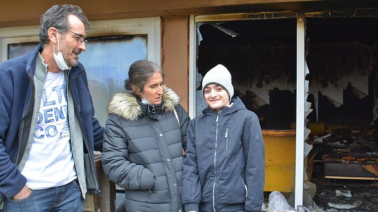 Die Familie Kocamaz vor ihrem vom Brand stark in Mitleidenschaft gezogenen Haus. Die Eltern Mustafa und Leyla sind stolz auf ihren Sohn Emre-Leo, der genau richtig reagierte und Bruder und Freundin aus dem Obergeschoss rettete.