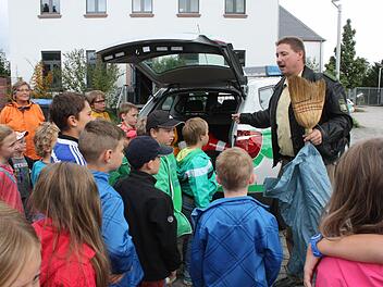 Dass ein ganz gewöhnlicher Besen auch zur Ausrüstung eines ganz modernen Dienstfahrzeuges der Polizei gehört, konnten die Kinder vor Ort feststellen. Foto: Arnold Nöth