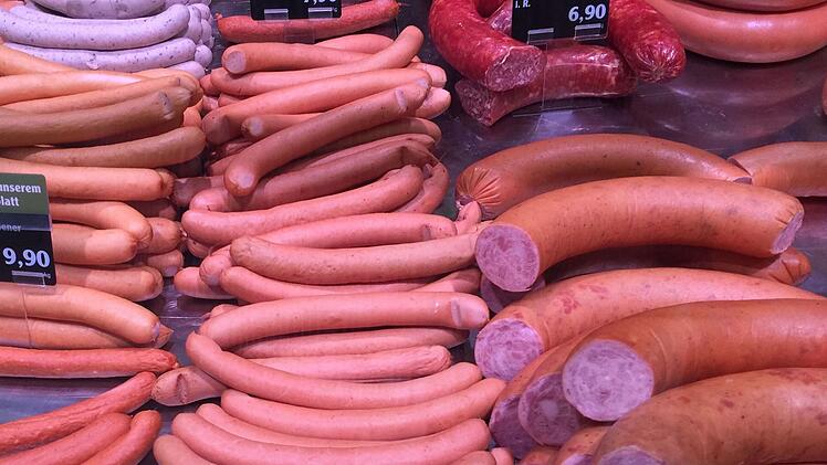 Eine appetitliche Auslage von Würsten in verschiedenen Sorten und Größen. Hinweistafeln zeigen Preise und Auswahl der Produkte an.