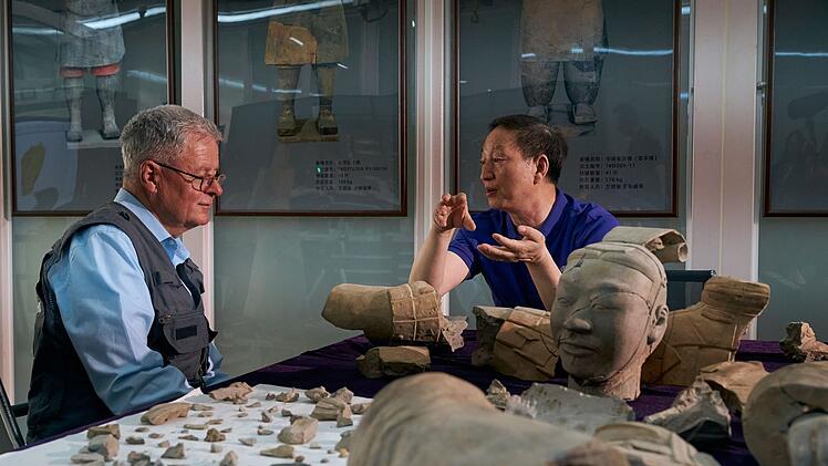 Der Konservator der Terrakotta-Armee, Lan Densheng, erkl&auml;rt Christopher Clark, wie herausfordernd die Arbeit an den Tonkriegern ist. Aus einzelnen Puzzleteilen werden mittels KI wieder Krieger zusammengesetzt.