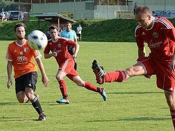 Ordentlich Leuchtfarben gab es beim TSV Wollbach zu sehen. Hier bringt Obererthals "roter" Benedikt Hofbauer das Leder zum Fliegen, bestaunt vom orangenen Wollbacher Timo Trost. Foto: ssp