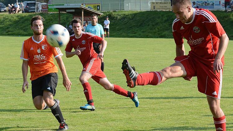 Ordentlich Leuchtfarben gab es beim TSV Wollbach zu sehen. Hier bringt Obererthals "roter" Benedikt Hofbauer das Leder zum Fliegen, bestaunt vom orangenen Wollbacher Timo Trost. Foto: ssp