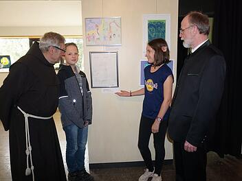 Nele Menz (Mittelpunktschule Hilders) befasste sich in einer Schwarz-Weiß Zeichnung mit dem Thema "Vergebung Grenzenlos". Christopher Knacker (Grundschule Wüstensachsen) ist ein weiterer junger Künstler, der sich an dem Projekt beteiligte. Mit im Bild Pater Martin Domogalla und Pfarrer Dr. Heinrich Maicher, die sich von der jungen Künstlerin ihr Werk erläutern lassen. Marion Eckert