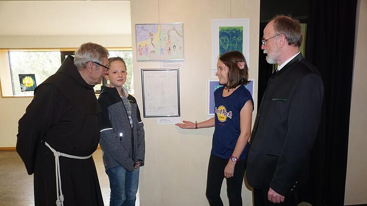 Nele Menz (Mittelpunktschule Hilders) befasste sich in einer Schwarz-Weiß Zeichnung mit dem Thema "Vergebung Grenzenlos". Christopher Knacker (Grundschule Wüstensachsen) ist ein weiterer junger Künstler, der sich an dem Projekt beteiligte. Mit im Bild Pater Martin Domogalla und Pfarrer Dr. Heinrich Maicher, die sich von der jungen Künstlerin ihr Werk erläutern lassen. Marion Eckert