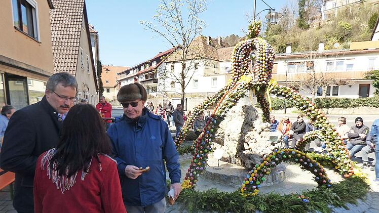 Ehrenbürger Heinz Gerhäuser (mit Sonnenbrille) im Gespräch mit Heimatvereinschefin Maria Eckert-Rosenberg und Bürgermeister Thomas Thiem vor dem Osterbrunnen