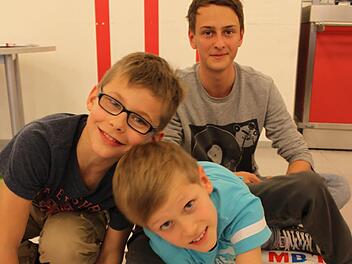 Tim und Nick aus der Sinnberg-Grundschule spielen am liebsten "Mathematik-Twister". Jan Ertl vom Jack-Steinberger-Gymnasium betreut die Viertklässler und kontrolliert die Rechenergebnisse. Foto: Carmen Schmitt