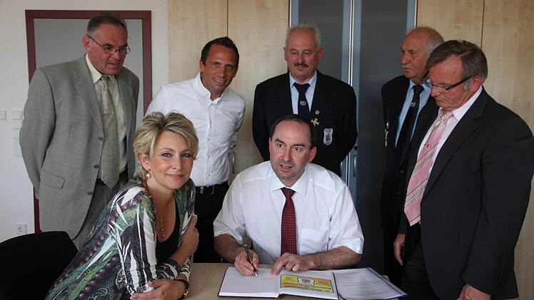 Claudia Jung (l.) und Hubert Aiwanger tragen sich ins Goldene Buch der Gemeinde Pinzberg ein