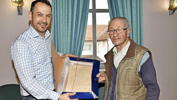 Raimund Vogt (rechts) überreichte Bürgermeister Holger Baunacher 59 Schriftstücke, die Auskunft über die Andreas-Kirche in Wonfurt geben.