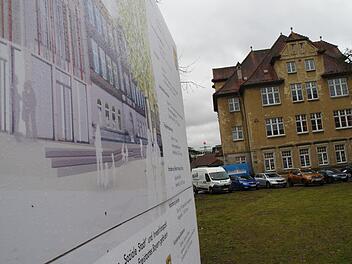 Die Baustellentafel zeigt, wie die herausgeputzte VHS nächstes Jahr aussehen soll. Die ehemalige Stadtbücherei wirkt dagegen in die Jahre gekommen.